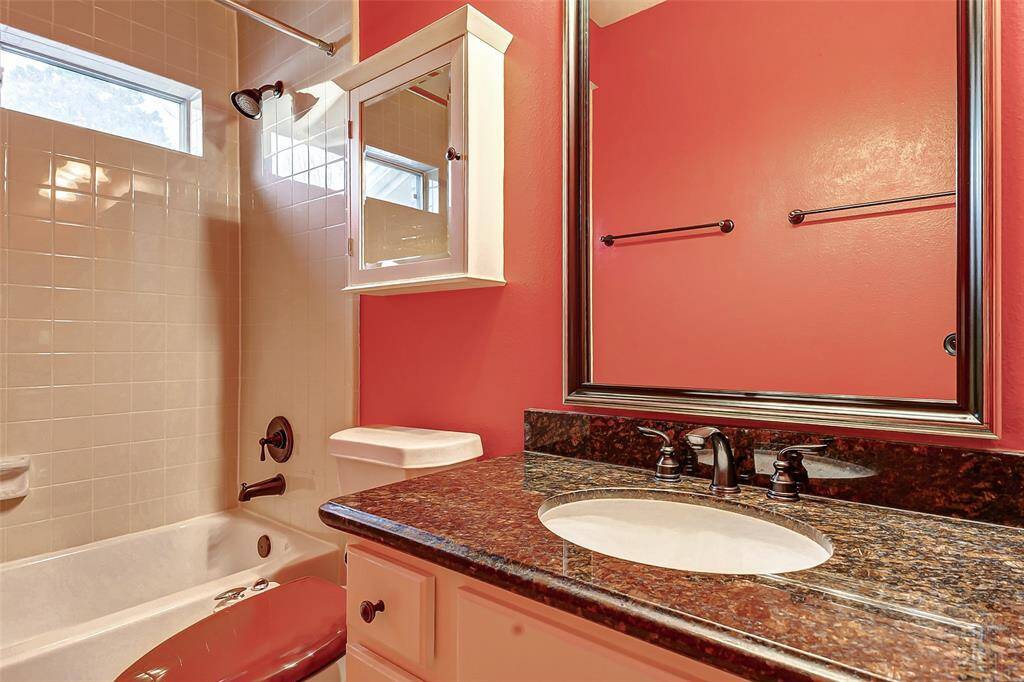 The secondary bath is conveniently located near the second bedroom downstairs, offering easy access to the kitchen, family room, and back patio for added convenience.
