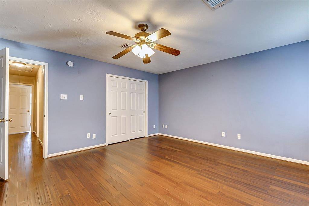 Bedroom 5 offers wood floors, lighted ceiling fan, and decorative paint color.