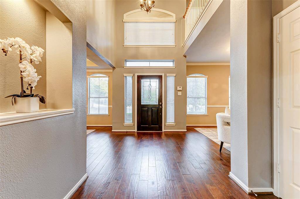 Step into a grand two-story entry, where sprawling wood floors flow throughout—carpet-free!