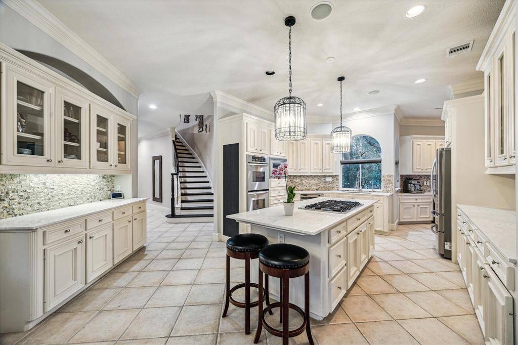 This light and bright kitchen with elegant cabinets and tile floors is an enviable place to entertain.
