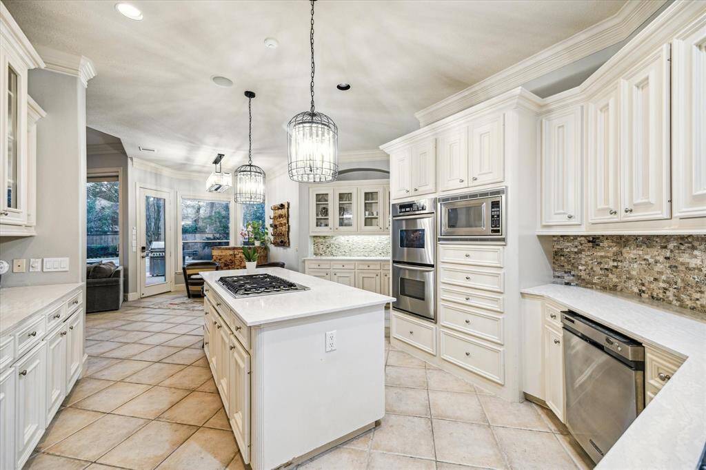 The gourmet kitchen features all high-end appliances including a 5-burner stove on the center island double ovens.