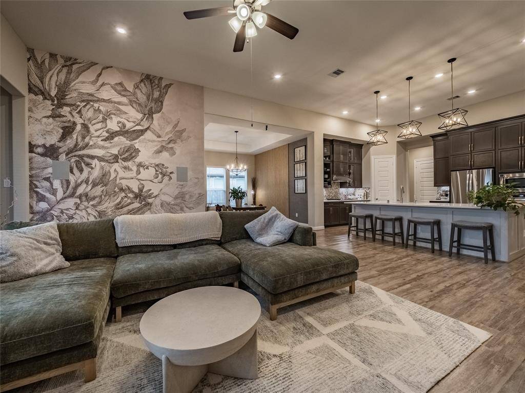 from this view you can see the seamless flow of the floor plan from the kitchen to the dining room and family room the entrance on the left is the entrance to the half bath and the guest bedroom with private bath