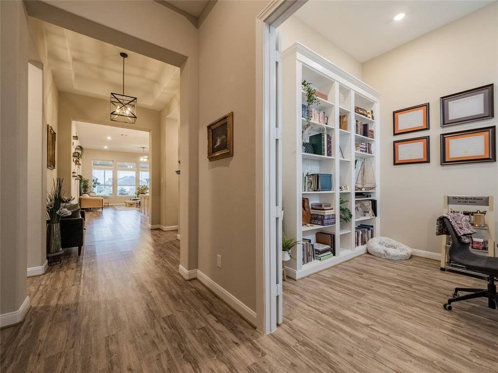 the office has double doors very spacious for the work from home person, tall ceilings recessed lighting straight ahead is a peek of the family room