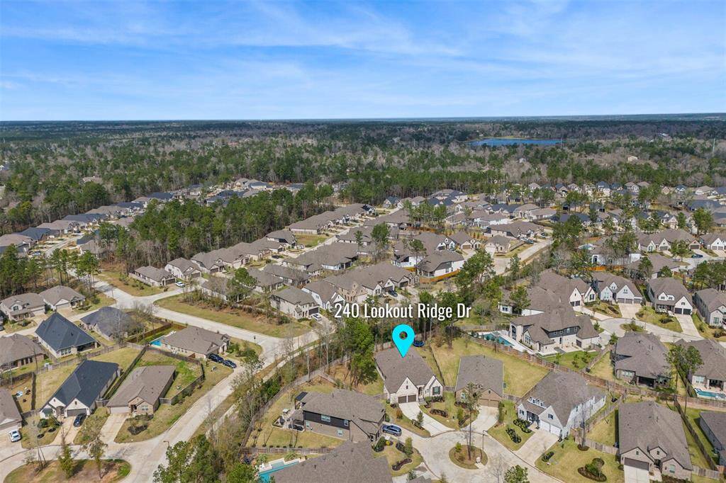 This aerial photo features a suburban neighborhood with well-spaced homes surrounded by greenery. The highlighted property at 240 Lookout Ridge Dr is centrally located, offering a spacious yard and proximity to wooded areas, providing a blend of community living and natural beauty.