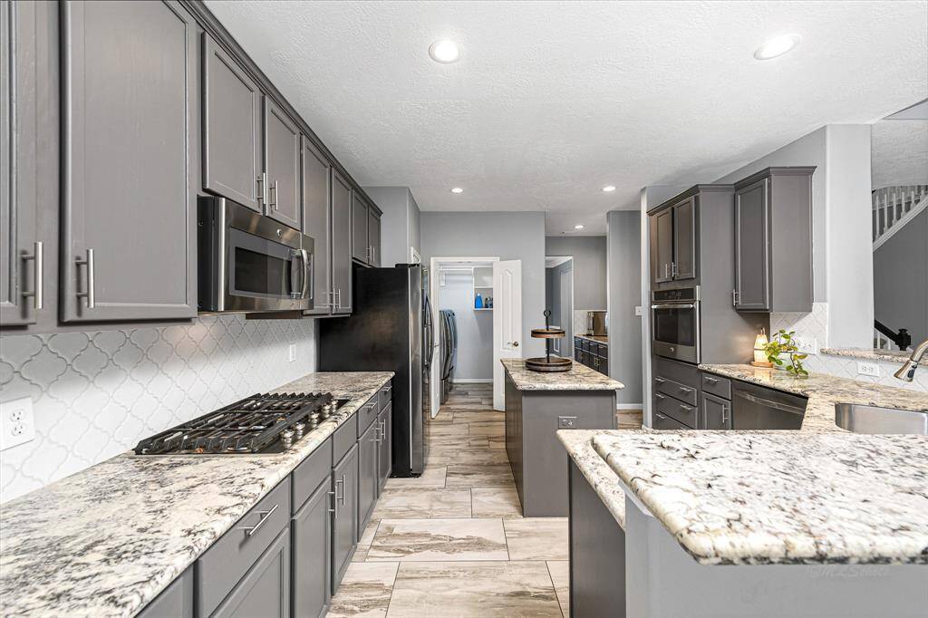 Open island kitchen with recessed lighting and gas cooktop