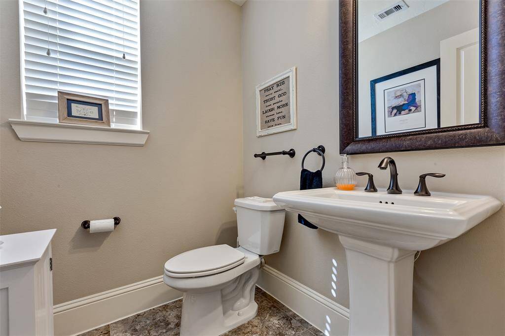 Guest half bath located downstairs is discretely tucked away.