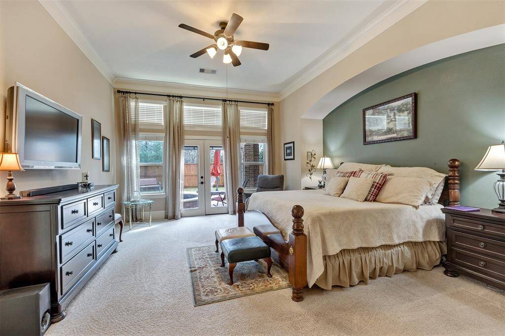 The spacious primary suite has floor to ceiling windows allowing for natural lighting and a view of the pool.