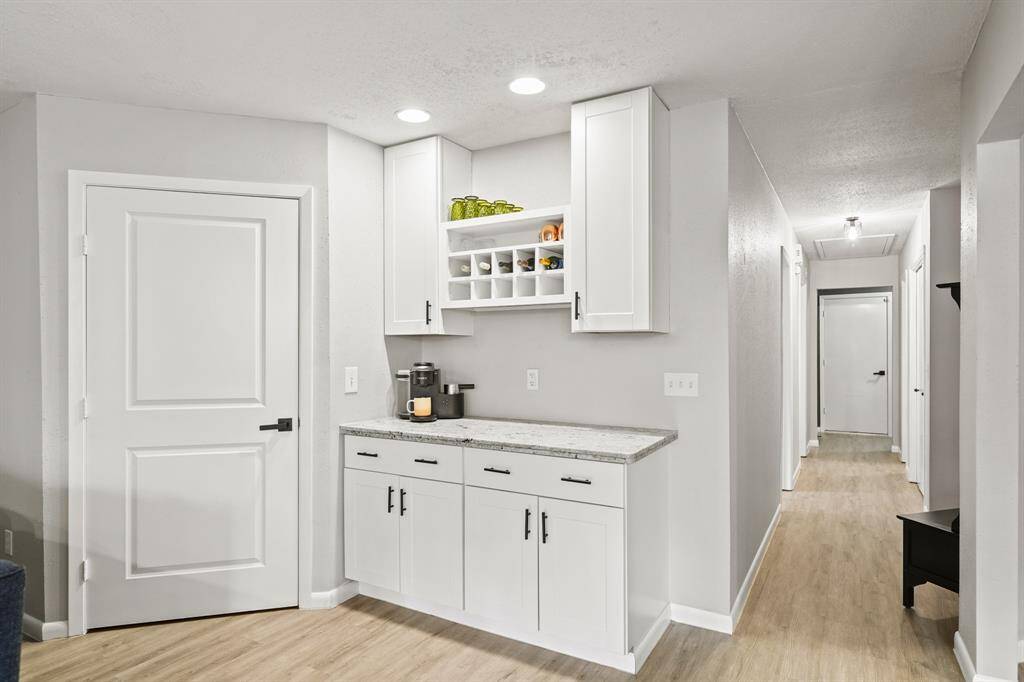 Perfect as a coffee bar, dry bar or butler's pantry, this area includes painted Shaker-style cabinets with a granite serving bar accompanied by upper & lower cabinet storage, a built-in wine rack & recessed lighting.
