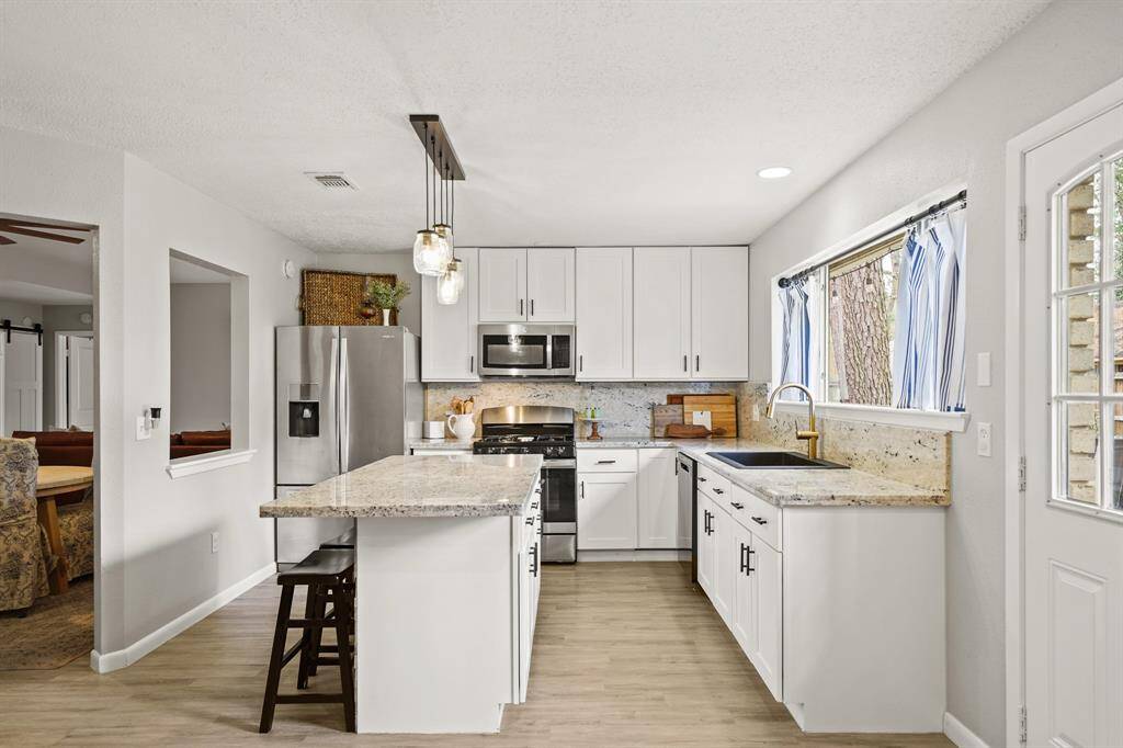 Just opposite the family room is the kitchen which includes 42" painted Shaker-style cabinets highlighted by granite counters and back splash & luxury vinyl plank hardwood floors.