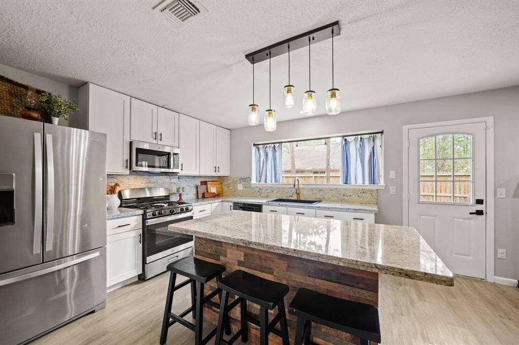 The stainless steel appliance package installed in 2021 includes a 4-burner gas range with conventional oven below and a built-in microwave oven with ventilation and lighting above. A new dishwasher was installed in 2023. As an added bonus, the stainless steel French door refrigerator with door mounted ice & water dispenser remains with the home.