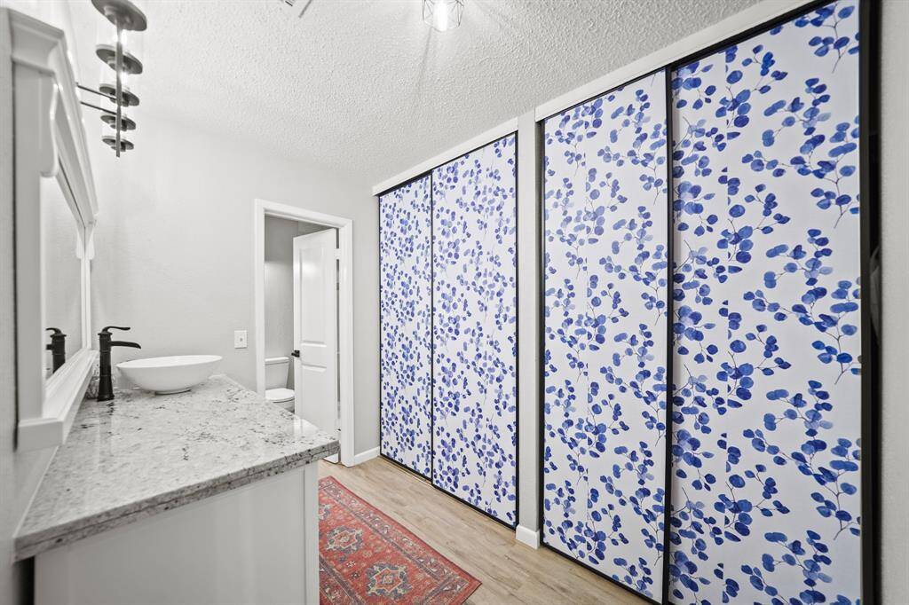 The updated private bath includes an entire wall of sliding doors dedicated to a wardrobe closet.