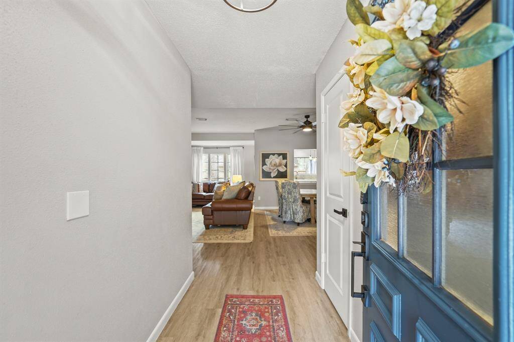 Featuring luxury vinyl plank hardwood flooring throughout the entire home, the foyer includes a painted front door with privacy rain glass, ceiling mounted lighting, a coat storage closet and opens to the formal living & dining rooms.