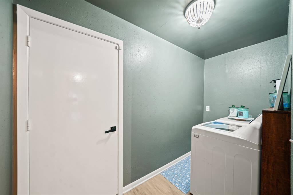 The utility room with ceiling mounted lighting includes space for a full size washer & dryer.