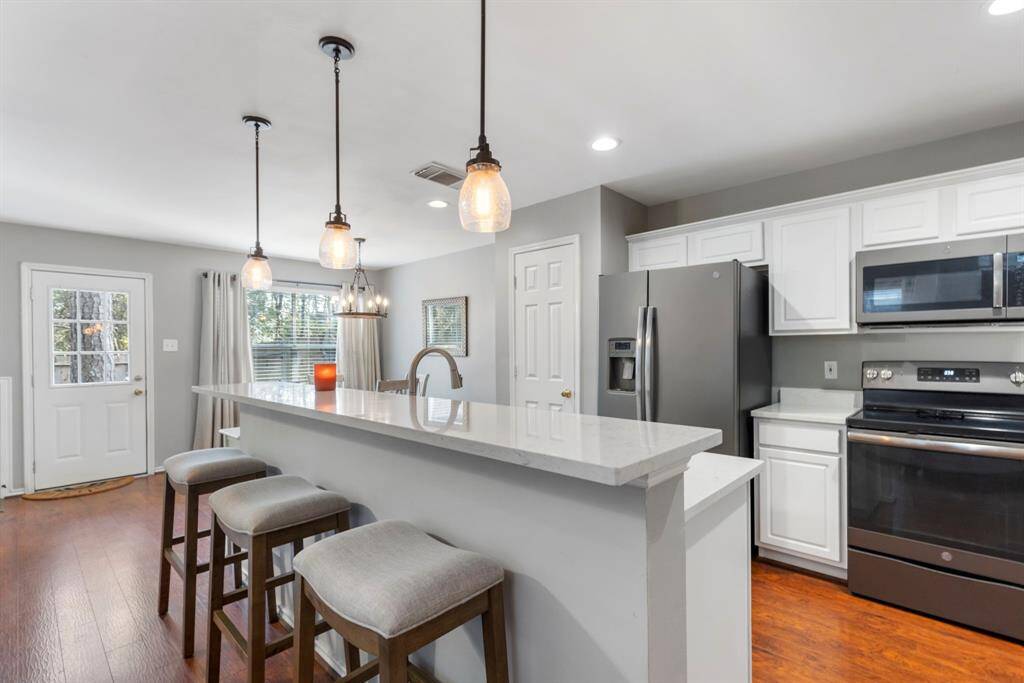 The spacious island features breakfast bar seating, offering a perfect spot for casual dining or entertaining guests.