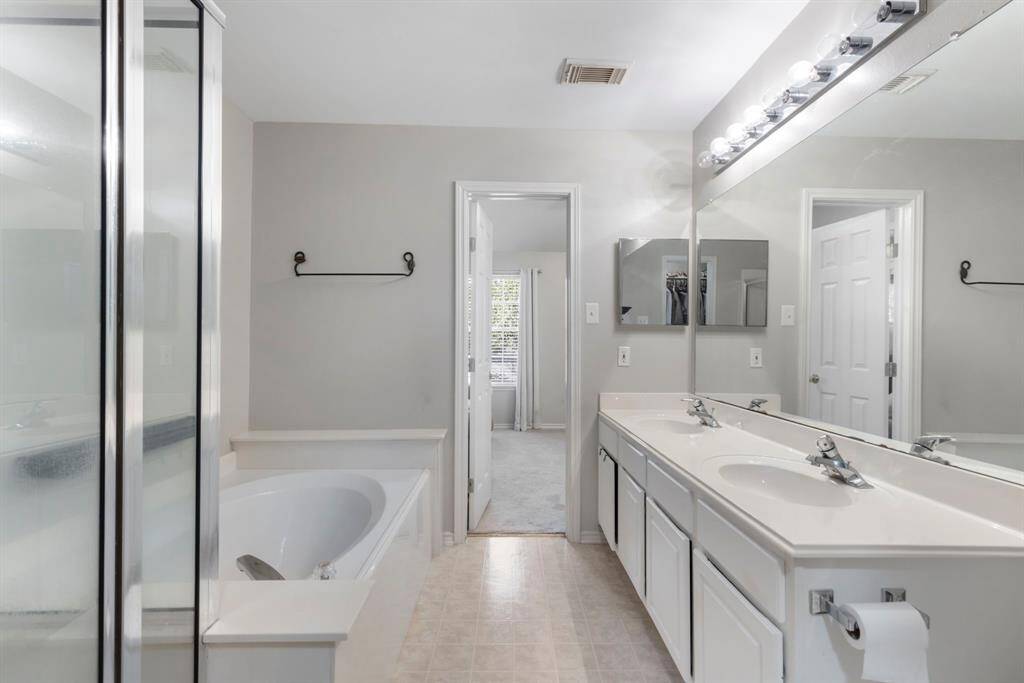 The primary bathroom boasts a spacious soaking tub and a separate walk-in shower, offering a luxurious and relaxing retreat.