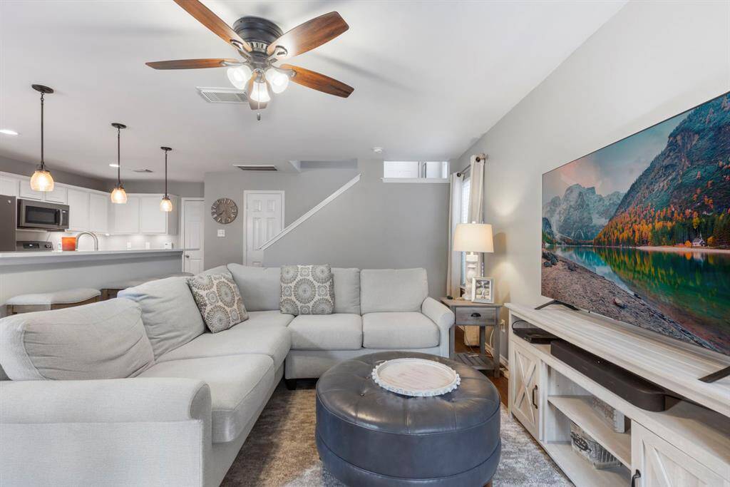 The cozy family room boasts neutral paint and laminate wood flooring throughout, providing a warm and inviting atmosphere that complements any décor style.