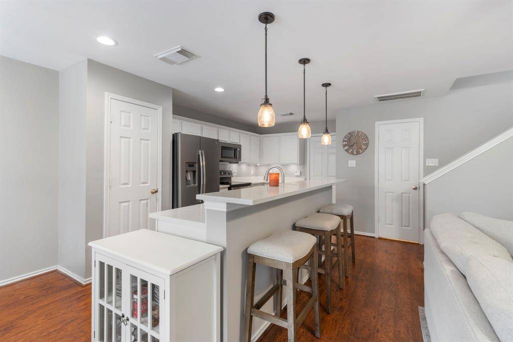 The kitchen features sleek quartz countertops and modern stainless steel appliances, perfect for both cooking and entertaining.