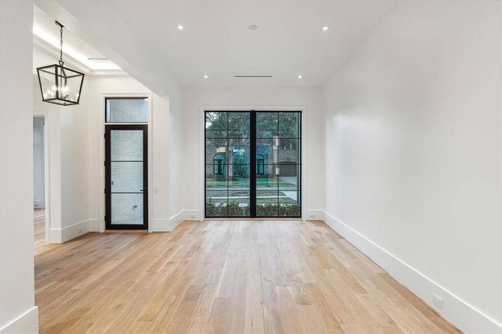 [Foyer / Dining Room]Open to the foyer. the dining room includes double-span, full-length windows that overlook the front lawn, driveway, and gardens.