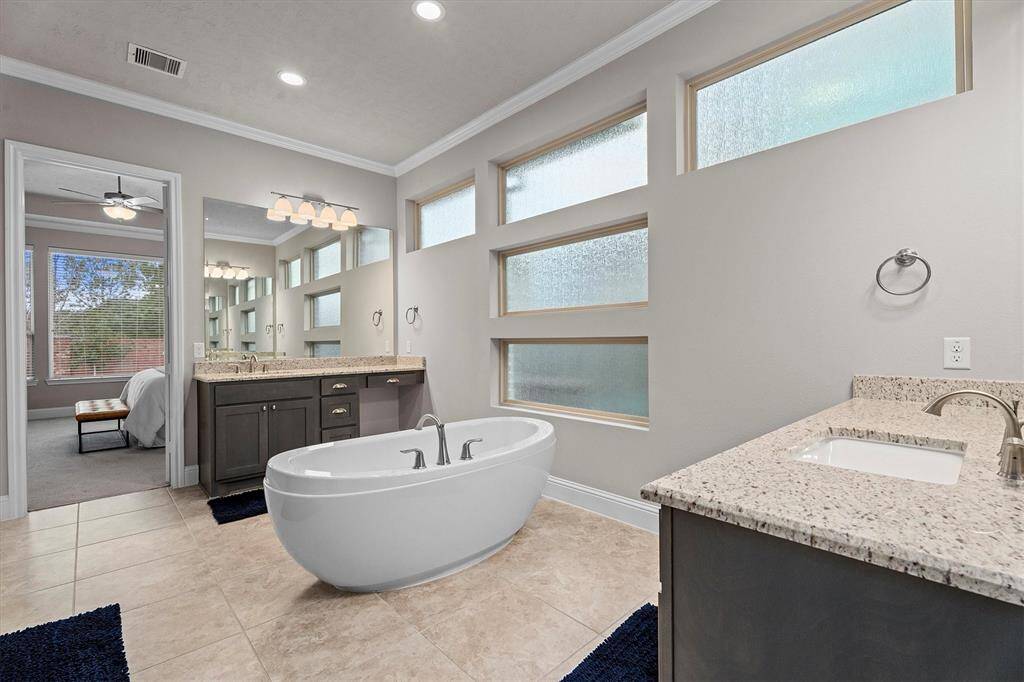 Big and bright primary bathroom has his and hers sink areas along with beautiful free standing tub.