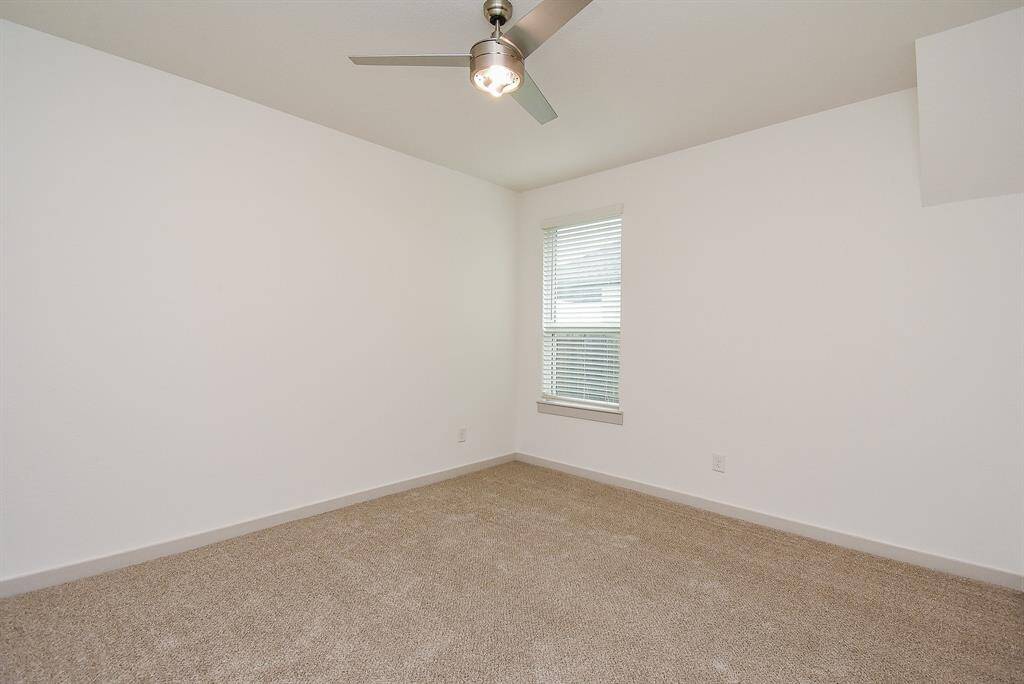 A corner window in a secondary carpeted bedroom means more wall and floor space for bedroom pieces and favorite accents.