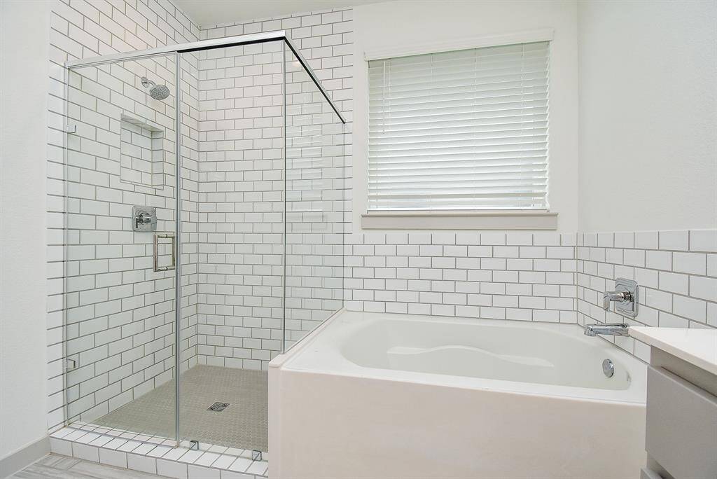 How inviting! Garden tub and roomy glass enclosed shower sit side-by-side in this appealing primary bathroom.
