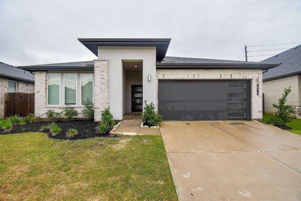 A contemporary/modern vibe is inviting, in this front exterior view of the recessed, covered main entrance. Inside, are 4 bedrooms and 3 bathrooms, sitting on a 7,467 square-foot-lot with 2,379 square-feet of lush interior living space.