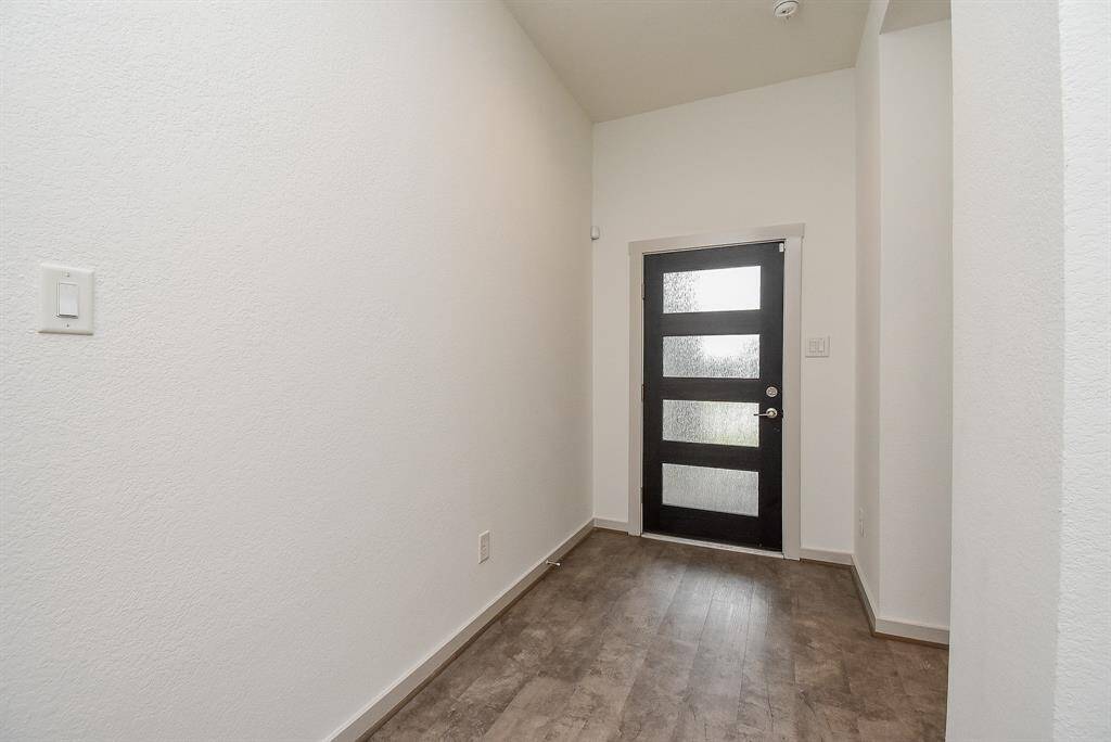 The main entry, from the inside, offers cool walls and wood-look tile (?) flooring.