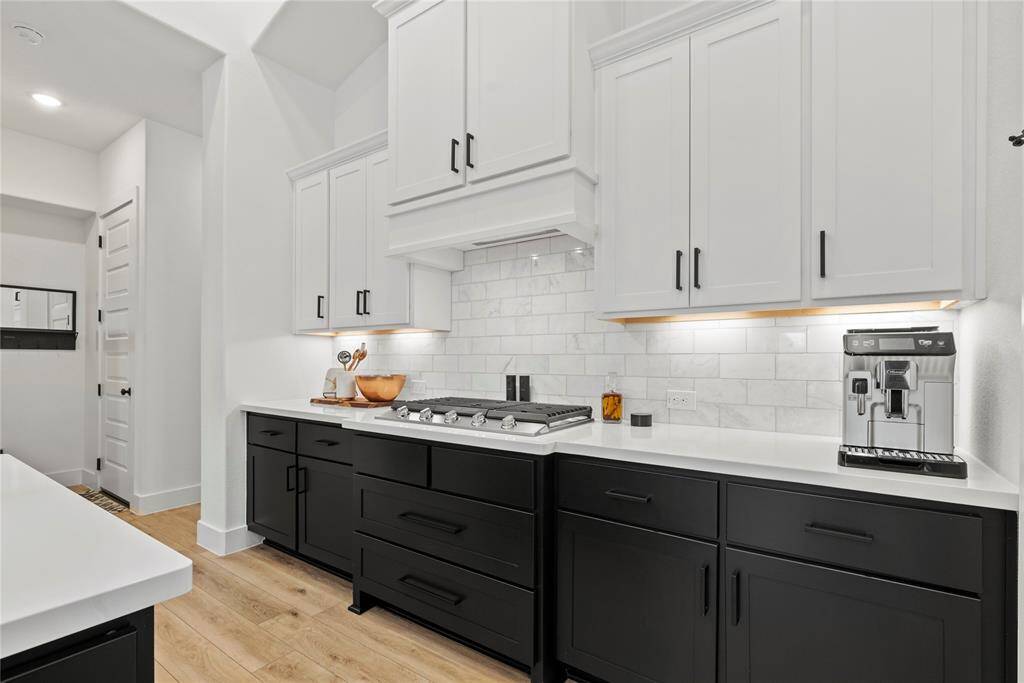 Quartz countertops paired with a coordinating stone backsplash not only provide a durable and elegant surface for food preparation but also add a touch of luxury and sophistication to the kitchen.