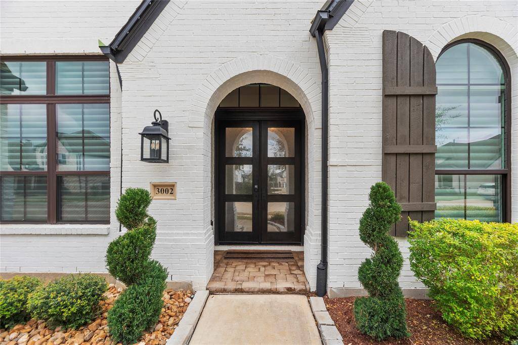 The elegant double leaded glass front doors invite abundant natural light, beautifully illuminating the entryway.