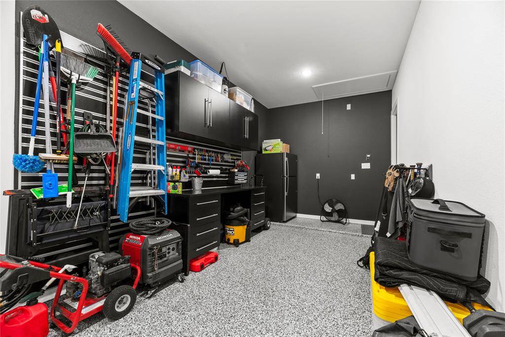 The garage boasts custom-built shelving, providing ample storage and organization for all your tools and essentials.