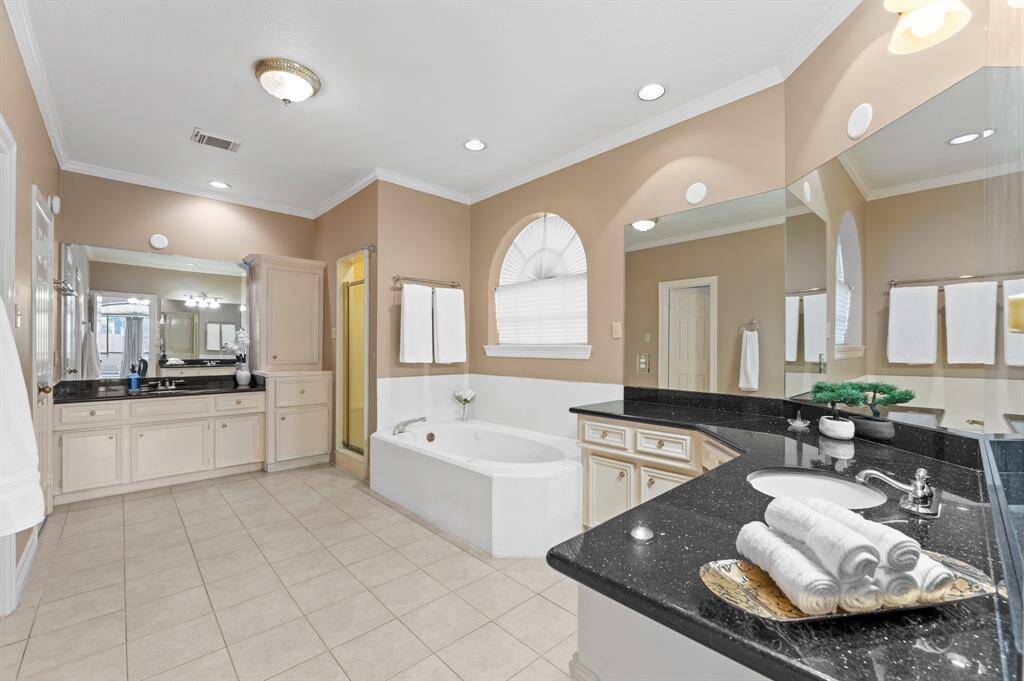 Spacious ensuite masterbath with enclosed separate sinks, enclosed water  and linen closets