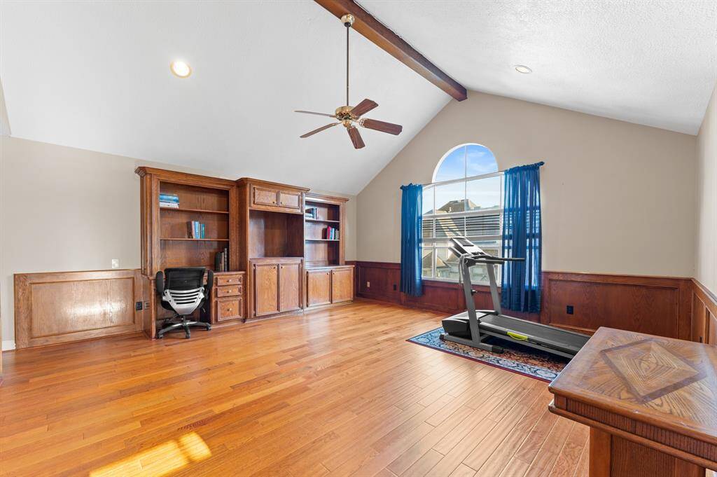 2nd floor gameroom/flex space with oak flooring and built in shelving/storage unit