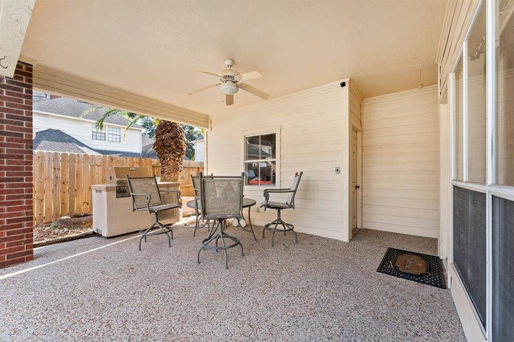 Backyard covered patio and outdoor kitchen with access to 2 car garage and pool