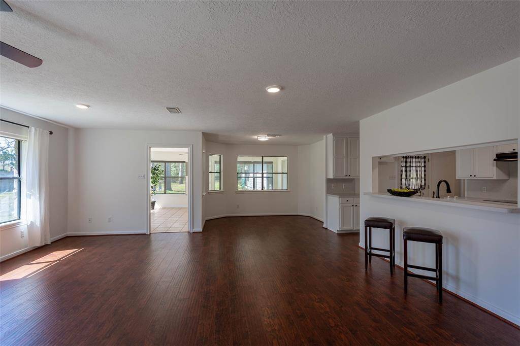 additonal living room view showing sunroom entry, and breakfast bar and dining area