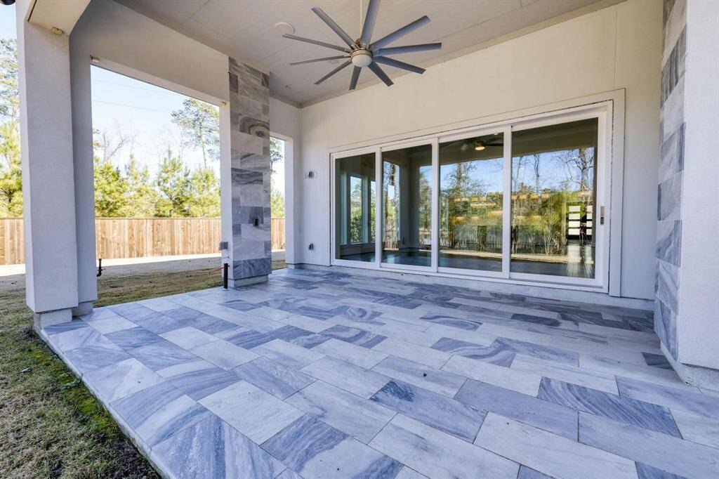 This  luxury modern home features a striking two-story entrance with large chandelier and large  windows, a sleek façade, and a well-maintained  lawn. The drive way offers ample space, and the overall design emphasizes clean lines and contemporary style.