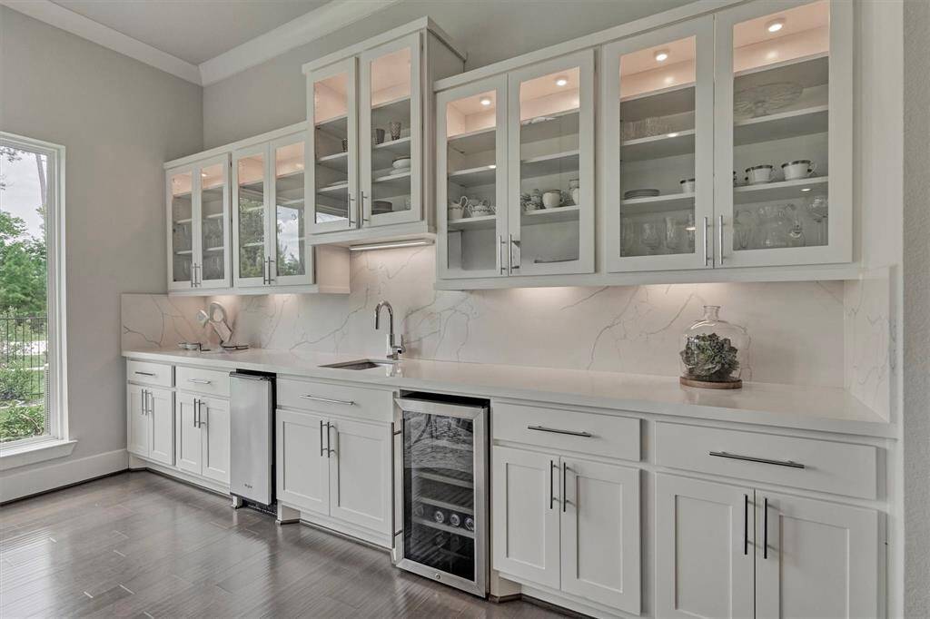 This spacious, open-concept living and dining area features large windows offering abundant natural light and views of the greenery outside. The room has elegant hardwood floors, a modern chandelier located in the dining room , and a a cozy seating area near sliding glass doors. Perfect for entertaining and family gatherings.