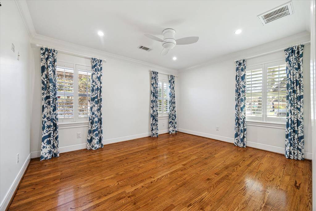 Spacious secondary bedroom with plantation shutters and double door closet with custom closet system. Custom crown molding, recessed lighting and hard wired for wall mounted TV.