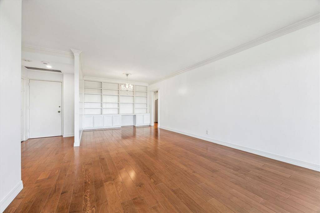 Dining room with hardwood floors, chandelier and crown molding.