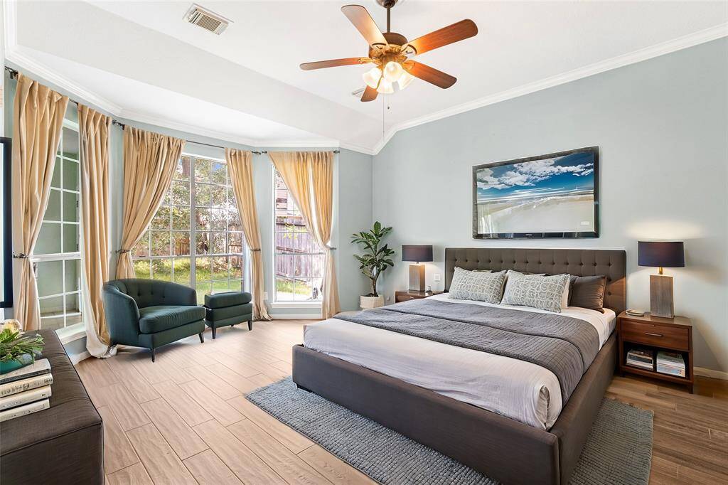 The spacious primary bedroom is located off of the great room with ample natural light, and a ceiling fan, offering a view of the backyard. *virutally staged*