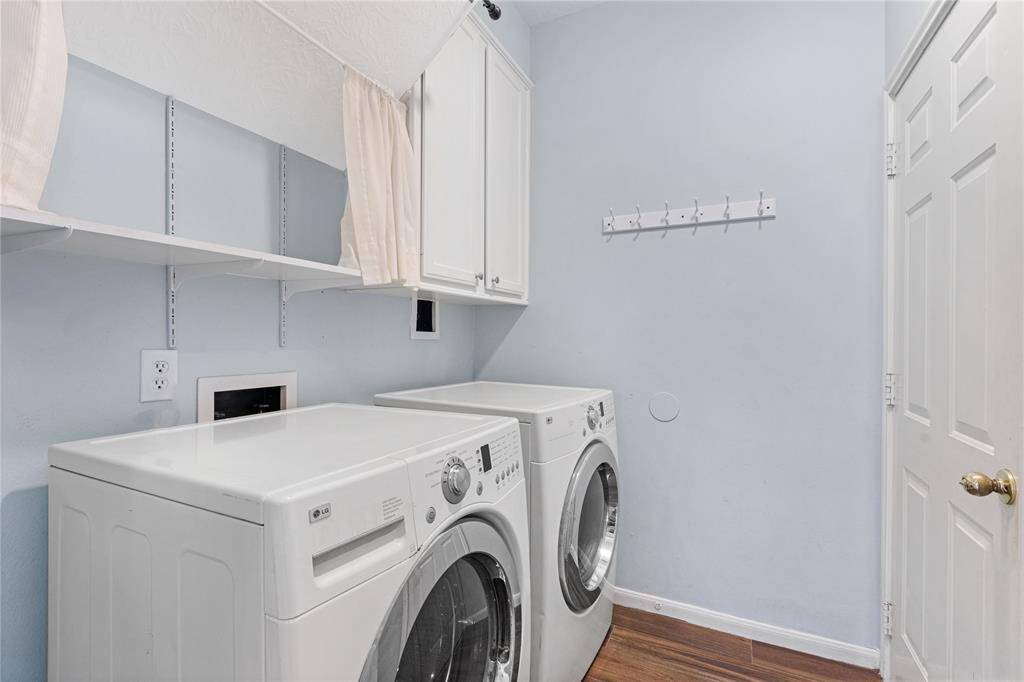 Functional laundry room featuring a washer and dryer set, ample shelving for storage