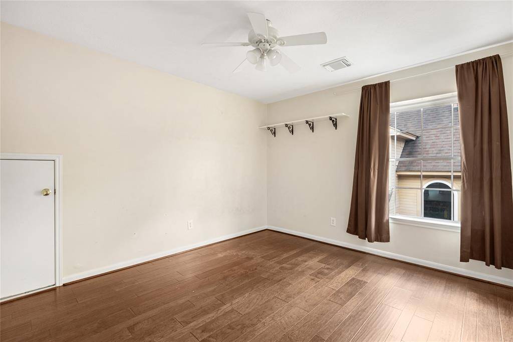 Another upstairs bedroom featuring wood laminate flooring, neutral wall colors, and  a ceiling fan