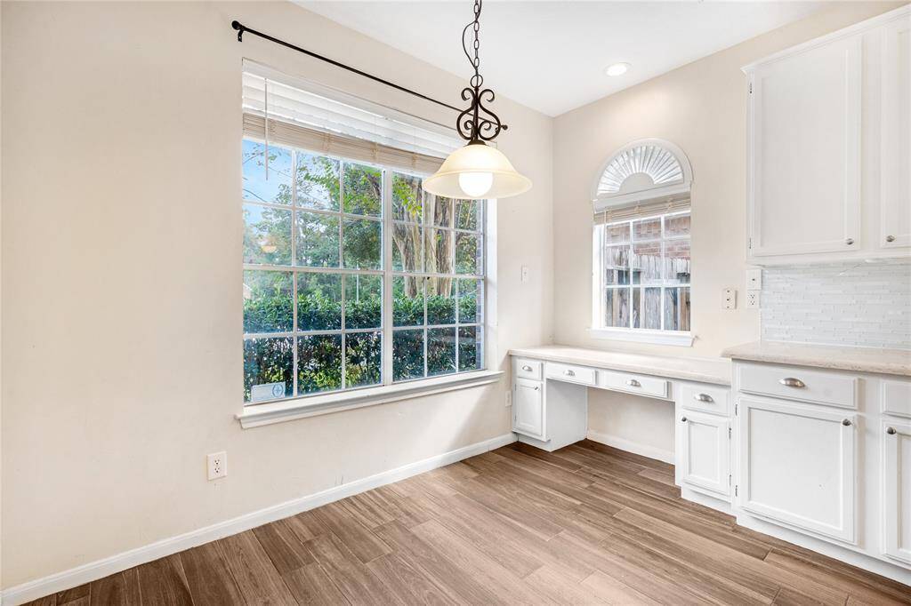 Cozy kitchen nook with large windows providing natural light,  elegant countertops, and modern flooring. Perfect for casual dining or a workspace with a view.
