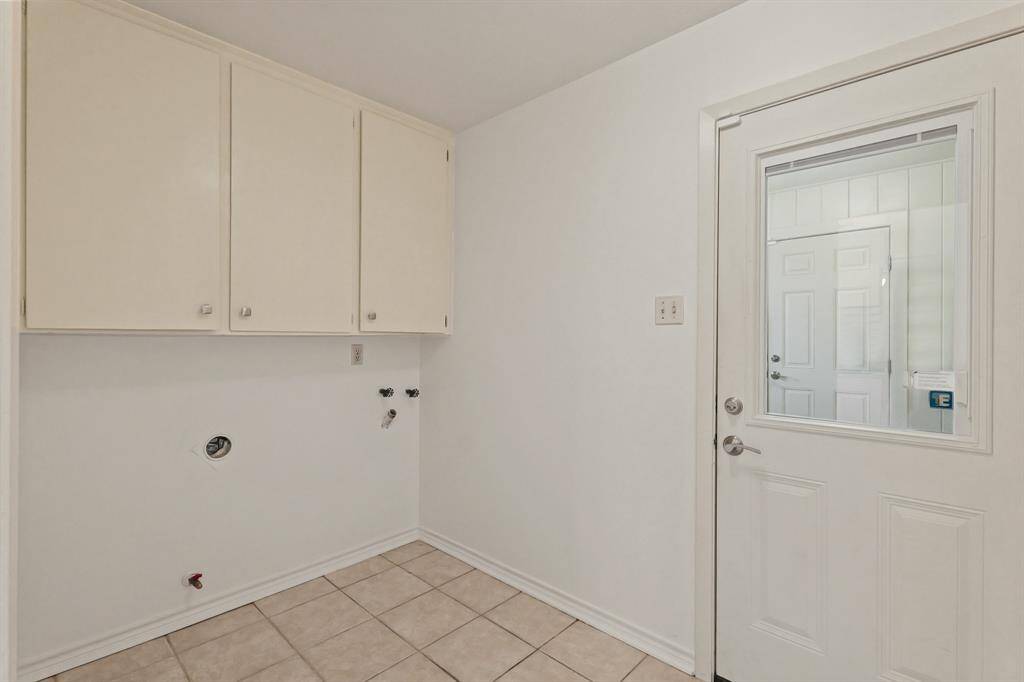 Spacious indoor laundry room with built in cabinetry and a large storage room just outside the door. Connects to the garage so you stay warm and dry!