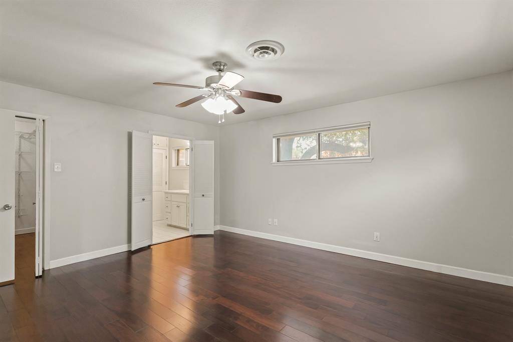 Primary suite looking into bath with ceiling fan and lighting.