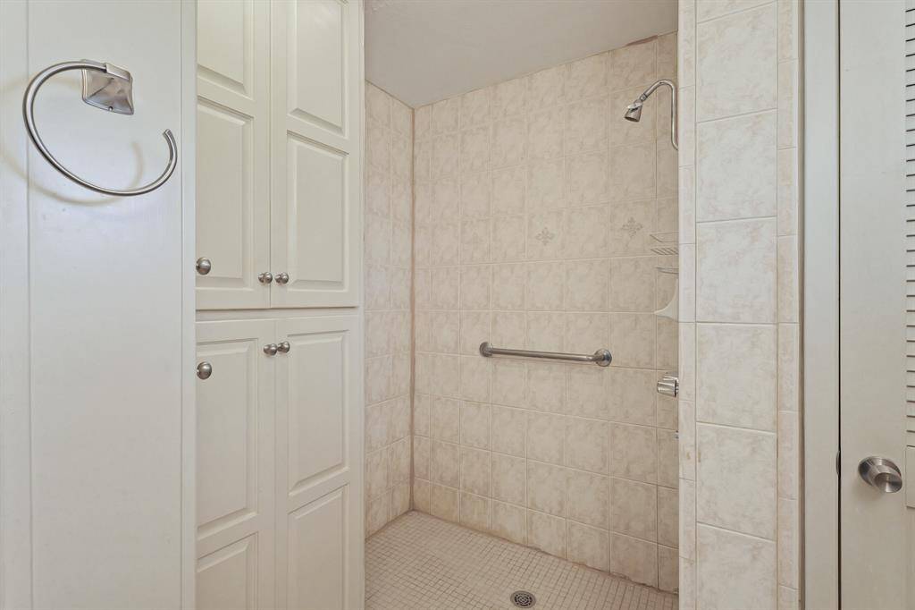 Spa-Like Walk-In Shower! The primary bath features a spacious walk-in shower, ample storage, and gold-tone fixtures.