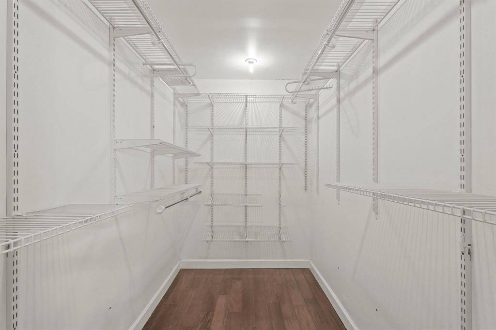 Primary bedroom walk in closet with custom storage solutions.