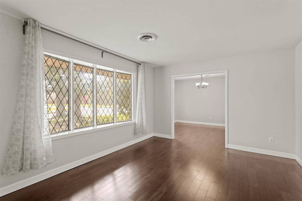 Formal Living Room with large windows overlooking the beautiful tree canopy of the front yard.