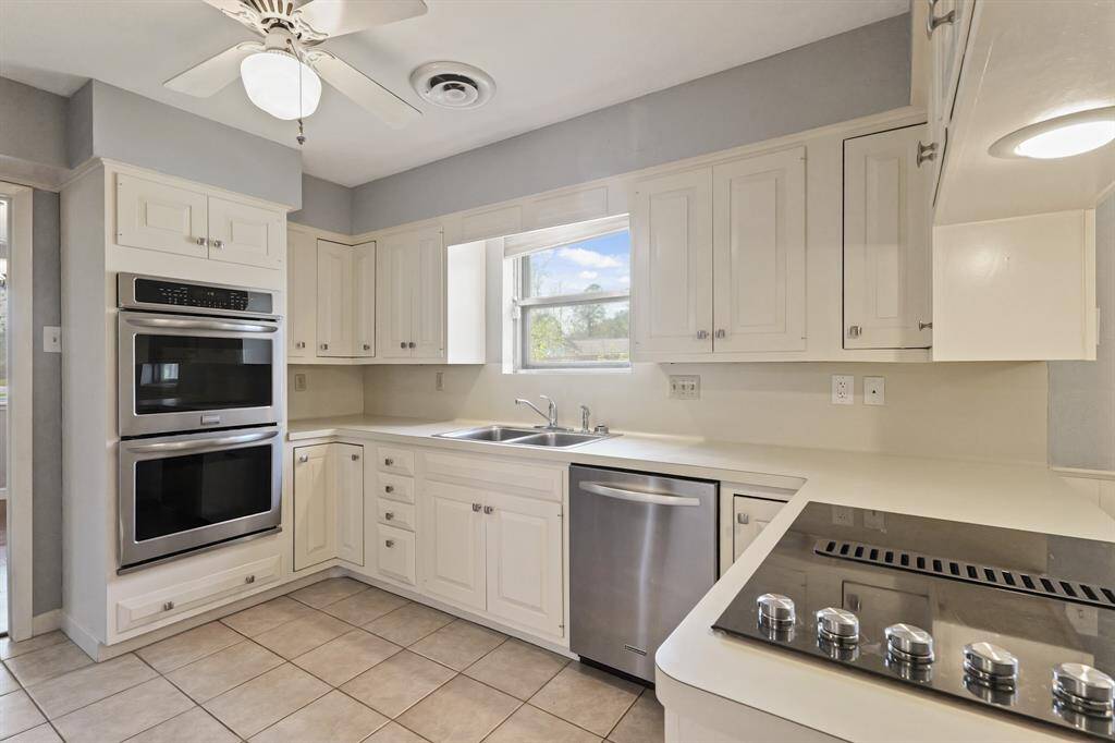 Kitchen with recent stainless steel appliances including double ovens, dishwasher, cooktop and trio door fridge/freezer.