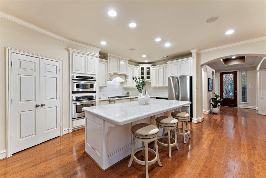 The kitchen features a spacious oversized island ideal for meal prep and social gatherings. With a modern backsplash and ample cabinetry, it seamlessly blends style and functionality.