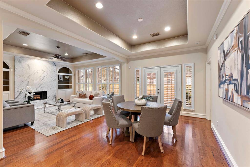 The vibrant breakfast and living area offers hardwood flooring, tray ceilings, and abundant natural light. French doors connect the spaces, allowing for seamless indoor-outdoor flow.